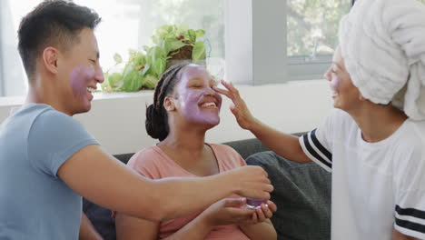 Young-Asian-man-and-two-young-biracial-women-enjoy-a-fun-skincare-routine-at-home