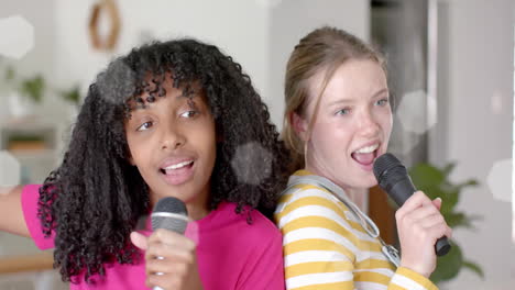 Animation-of-white-lights-over-happy-diverse-teenage-girls-with-microphones-singing-karaoke-at-home