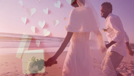 Animation-of-hearts-over-happy-diverse-just-married-couple-running-on-beach-by-sea