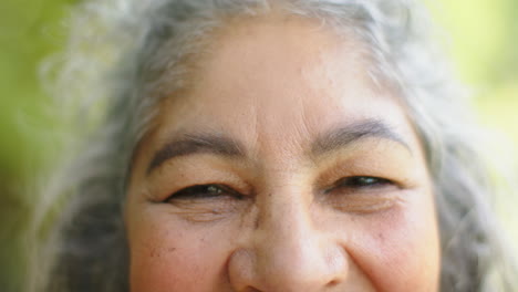 Close-up-of-a-senior-biracial-woman-smiling-with-her-eyes-closed,-outdoor