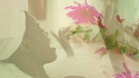 Animation-Von-Rosa-Blumen-über-Einer-Glücklichen-Afroamerikanerin,-Die-In-Der-Badewanne-Entspannt