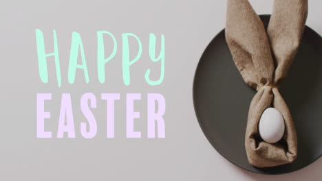 Animation-of-happy-easter-text-over-easter-eggs-in-cloth-on-white-background