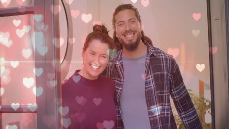 Animation-of-hearts-over-happy-diverse-couple-at-home