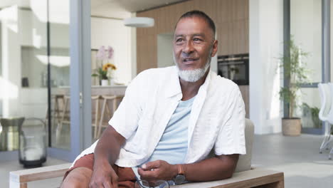 Biracial-man-in-his-fifties,-with-greying-hair,-sits-casually-dressed