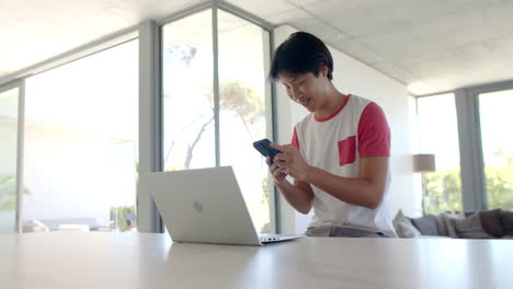 Teenage-Asian-boy-studying-at-a-bright-home-office