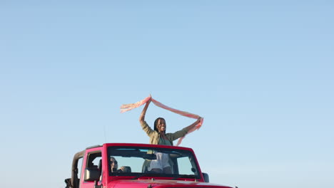 Young-African-American-woman-enjoys-a-carefree-moment-outdoors-on-a-road-trip,-with-copy-space