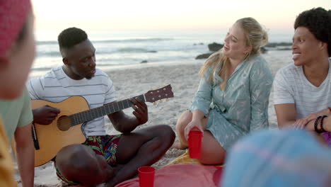 Junger-Afroamerikaner-Spielt-Auf-Einer-Party-Am-Strand-Gitarre