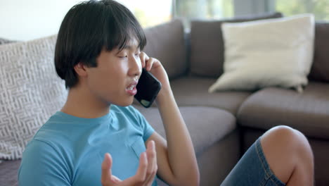 Un-Adolescente-Asiático-Enojado-Habla-Por-Teléfono-En-Casa