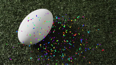 Animation-of-confetti-over-white-rugby-ball-on-grass