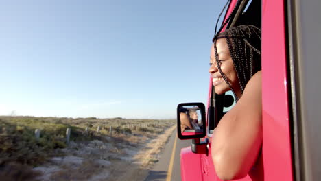 Young-African-American-woman-enjoys-a-car-ride-on-a-road-trip,-with-copy-space