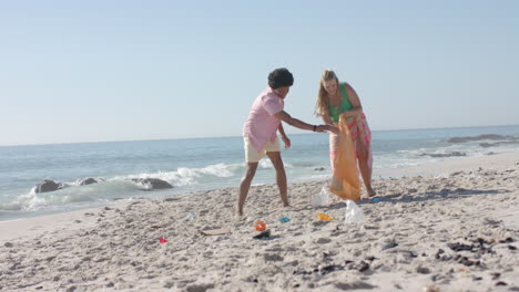 Young-Caucasian-woman-and-African-American-man-clean-up-a-beach,-with-copy-space