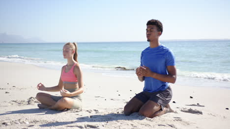 A-man-and-woman-are-meditating-on-a-sunny-beach-with-clear-skies