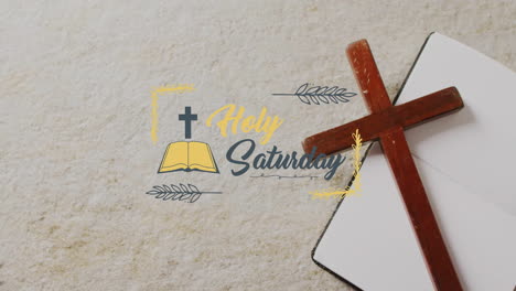 Animation-of-holy-saturday-text-over-christian-cross-and-book-on-grey-background