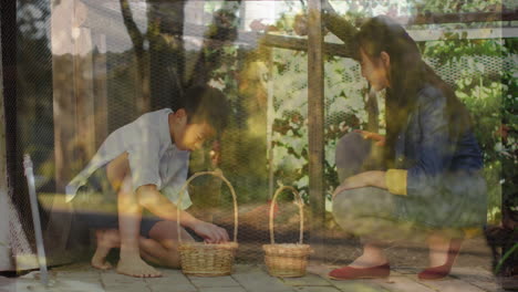 Animation-of-forest-over-asian-siblings-picking-eggs
