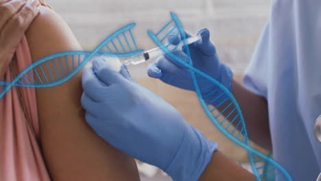 Animation-of-dna-strands-over-biracial-woman-being-vaccinated