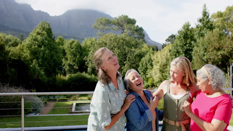Senior-diverse-group-of-women-share-a-laugh-outdoors,-with-copy-space