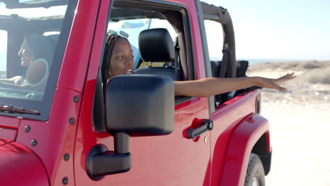 Young-African-American-woman-enjoys-a-ride-in-a-red-jeep-on-a-road-trip