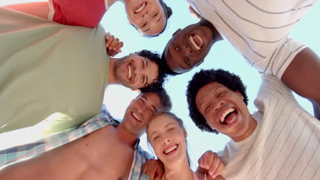 Diverse-group-of-friends-smile-in-a-huddle-outdoors
