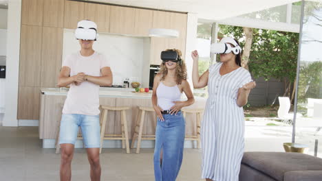 Young-Asian-man-and-two-young-biracial-women-enjoy-virtual-reality-at-home