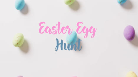 Animation-of-easter-egg-hunt-text-over-colourful-easter-eggs-on-white-background