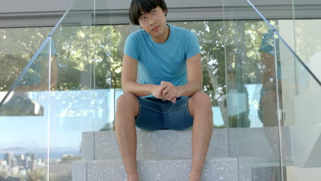 Teenage-Asian-boy-sits-on-outdoor-steps