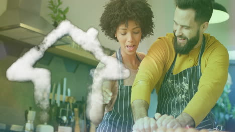 Animation-of-cloud-house-icon-over-happy-diverse-couple-cooking-in-kitchen