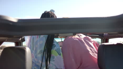 Young-African-American-woman-and-young-Caucasian-woman-enjoy-a-sunny-day-outdoors-on-a-road-trip