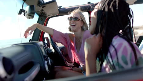 Young-African-American-woman-and-young-Caucasian-woman-enjoy-a-sunny-drive-on-a-road-trip