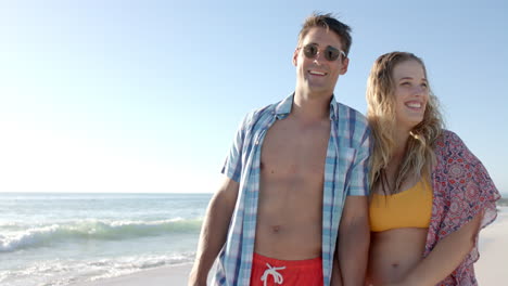 Caucasian-couple-enjoys-a-sunny-beach-day,-with-copy-space
