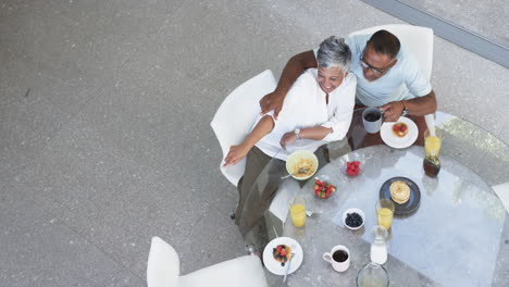 Biracial-couple-enjoys-a-healthy-breakfast-together,-with-a-top-down-view-with-copy-space