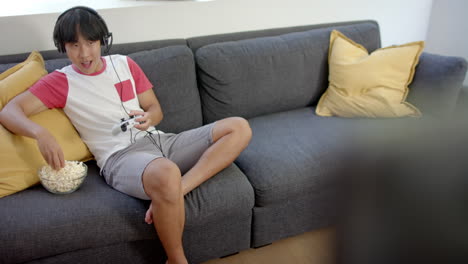 Teenage-Asian-boy-enjoys-gaming-in-a-home-setting-with-copy-space