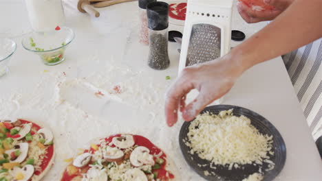 Hands-prepare-pizza-toppings-in-a-home-kitchen