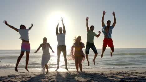 Diverse-friends-leap-joyfully-on-a-sunny-beach