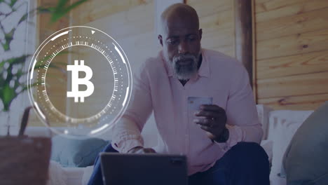 Animation-of-bitcoin-sign-and-data-processing-over-african-american-man-paying-with-card-online