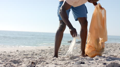 Ein-Junger-Afroamerikaner-Sammelt-Müll-Am-Strand