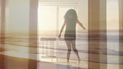 Animation-of-sunset-beach-over-biracial-teenage-girl-dancing-at-home