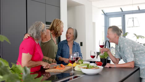 Eine-Gruppe-Hochrangiger,-Vielfältiger-Frauen-Lacht-In-Einer-Modernen-Küche-Beim-Zubereiten-Einer-Mahlzeit