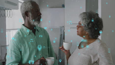 Animation-of-network-of-connections-with-icons-over-senior-african-american-couple-talking