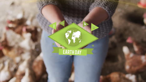 Animation-of-earthday-text-over-caucasian-woman-holding-seeds-with-chicken-in-background