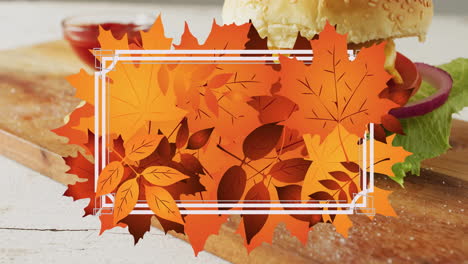 Animation-of-frame-with-fall-leaves-over-hamburger