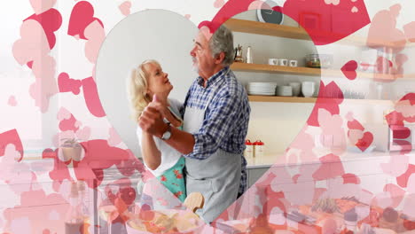 Animation-of-hearts-over-senior-caucasian-couple-dancing-in-kitchen