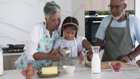 Biracial-grandparents-are-baking-with-a-young-biracial-girl-in-a-modern-kitchen