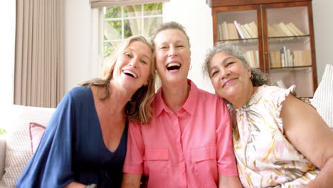Three-joyful-senior-women-share-a-close-moment-at-home