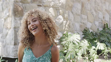 Young-biracial-woman-laughs-joyfully-outdoors,-with-copy-space
