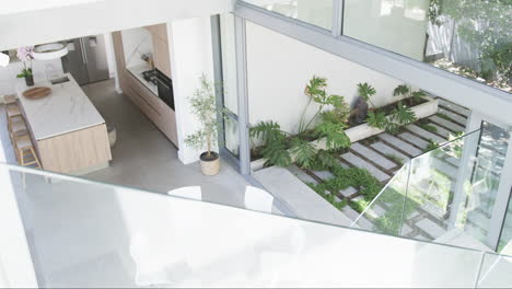 Eine-Moderne-Küche-Mit-Marmorarbeitsplatten-Blickt-Auf-Einen-Kleinen-Garten-Mit-üppigem-Grün