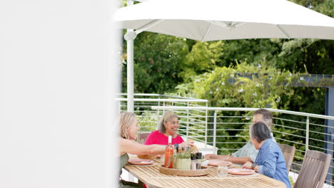 Senior-diverse-group-enjoys-a-meal-outdoors,-with-copy-space
