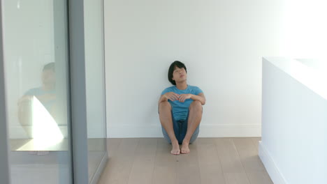 Teenage-Asian-boy-sits-alone-indoors,-with-copy-space