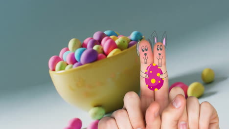 Animation-of-fingers-with-easter-bunny-faces-and-easter-eggs-on-blue-background