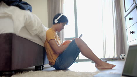 Teenage-Asian-boy-enjoys-music-at-home