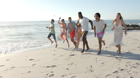 Diverse-group-of-friends-enjoy-a-beach-day,-with-copy-space